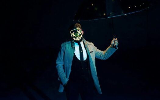 a man in a suit and mask holding an umbrella