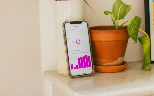 A cell phone sitting on top of a table next to a potted plant