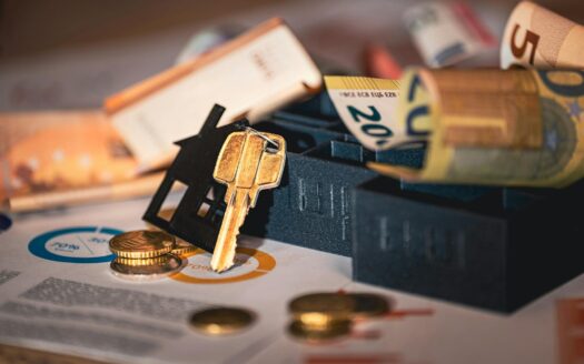 Close-up of house keys, euro bills, and charts symbolizing real estate investment and finance.